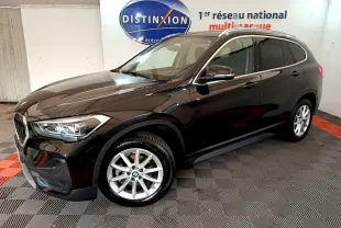 BMW X1 noir vue 3/4 avant droit, mettant en valeur ses phares LED et jantes alliage argentées.