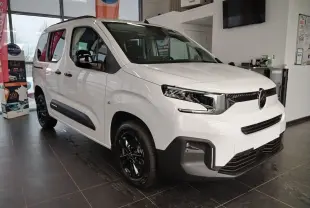 Citroën Berlingo blanc vue 3/4 avant droit en intérieur, avec jantes alu noir Starlit et rails latéraux couleur carrosserie.