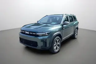 SUV Dacia Bigster vert cèdre en 3/4 avant droit, avec jantes alu 17 pouces et barres de toit visibles.