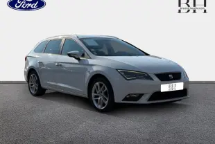 SEAT Leon ST blanc Candy vue 3/4 avant droit, avec jantes alu et barres de toit visibles.