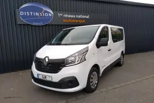 Renault Trafic Microbus blanc vu en 3/4 avant droit, avec calandre noire et vitres teintées arrière.
