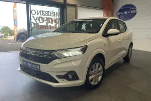 Dacia Sandero blanc vue 3/4 avant droit en showroom avec calandre noire et feux LED allumés.