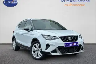 SEAT Arona blanc Nevada métal avec toit noir, vue 3/4 avant mettant en valeur la calandre et les jantes alu.