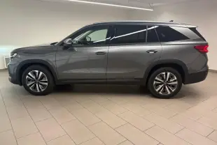 Vue de profil côté gauche du Skoda Kodiaq 2025 gris graphite avec jantes alliage et vitres teintées.