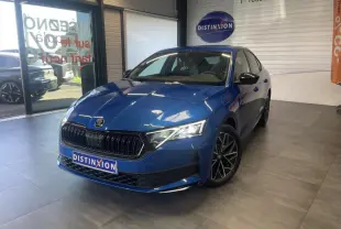 Skoda Octavia 2025 bleu foncé vue 3/4 avant en intérieur avec jantes alliage noires et calandre marquée.