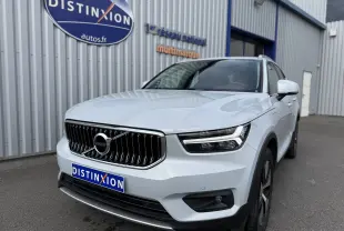 Vue 3/4 avant droite d'un Volvo XC40 blanc crystal metal, avec calandre verticale et phares LED distinctifs.