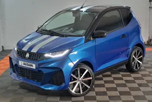 Vue 3/4 avant d'une Aixam Ambition 0.5 City GTO bleu métallisé avec bandes grises et jantes noires brillantes.