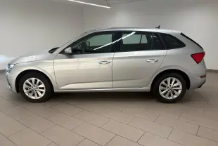 Vue de profil côté gauche d'une Skoda Scala gris argent 2024, version 1.0 TSI 110 DSG7 Business en intérieur showroom.