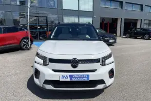 Vue avant d'une Citroën C3 Nouvelle blanche 2025 avec logo noir et plaque "Véhicules Occasions" sur parking.