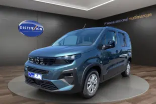 Peugeot Rifter bleu en vue 3/4 avant droit, avec calandre noire et jantes argentées, en showroom intérieur.