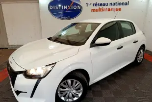 Peugeot 208 blanc vue 3/4 avant droit, phares allumés, sur sol damier noir et rouge en intérieur showroom.