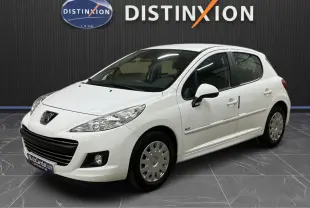 Peugeot 207 blanche vue 3/4 avant droit, avec calandre et baguettes de porte chromées, en intérieur showroom.
