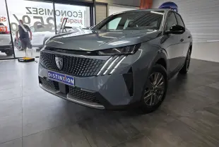 Peugeot 3008 bleu vue 3/4 avant droit en intérieur, avec calandre noire et feux LED à griffes distinctifs.