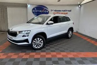 Vue 3/4 avant droite d’un Skoda Karoq blanc avec calandre noire et jantes alliage dans un showroom.