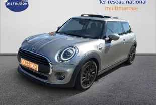 Vue 3/4 avant droit d'une MINI One beige avec jantes noires et toit ouvrant, stationnée sur sol gris.