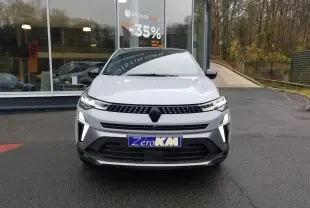 Vue frontale d'un Renault Captur gris Rafale 2025 avec éclairage LED distinctif et plaque "Zéro KM" visible.
