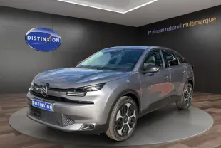 Citroën C4 hybride gris foncé vue 3/4 avant droit, avec phares LED et jantes distinctives en exposition showroom.