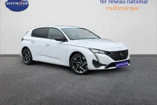 Peugeot 308 blanc Okénite vue 3/4 avant droit, jantes alliage et calandre noire distinctive.