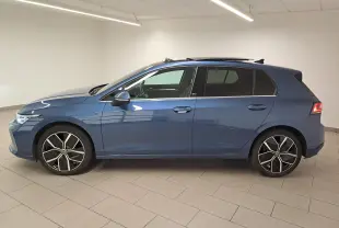 Profil droit d'une Volkswagen Golf 1.5 eTSI 150 DSG7 Edition 50 en bleu Anémone avec toit ouvrant panoramique et jantes stylées.
