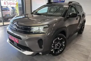 Citroën C5 Aircross gris platinium en 3/4 avant droit, avec jantes alliage bi-ton et calandre noir brillant.