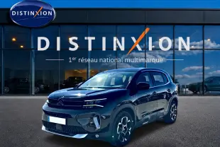 Citroën C5 Aircross noir vue 3/4 avant, avec jantes alu et calandre distinctive devant showroom Distinxion.