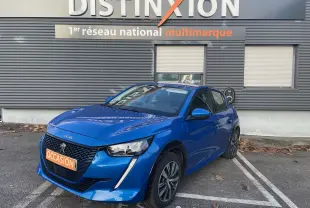 PEUGEOT E-208 136CH ACTIVE bleu électrique, vue 3/4 avant droit, stationnée devant un mur gris avec panneau Distinxion.