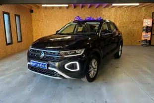 Volkswagen T-Roc noir 2022 en 3/4 avant droit avec éclairage LED distinctif, stationné dans un garage intérieur.