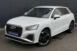 Audi Q2 30 TFSI S-Line blanc Glacier vue 3/4 avant, avec jantes alliage noir poli et calandre noire distinctive.
