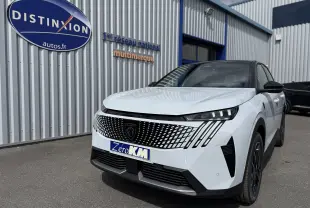 Vue 3/4 avant droit d’un Peugeot 3008 Hybrid blanc Okenite avec toit noir, calandre distinctive et phares LED marqués.