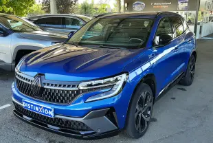 Renault Austral E-Tech 200 Techno Esprit Alpine bleu Iron, vue 3/4 avant sous abri avec calandre distinctive noire.