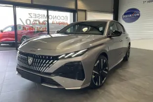 Peugeot 308 gris Artense vue 3/4 avant droit en intérieur avec calandre noire et jantes bi-tons.