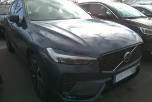 Vue 3/4 avant gauche d'un Volvo XC60 bleu avec calandre noire laquée et jantes alliage 20 pouces en Y.