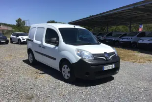 Renault Kangoo blanc vu en 3/4 avant droit, avec pare-chocs noirs et vitrage teinté, stationné sur un sol gravillonné.