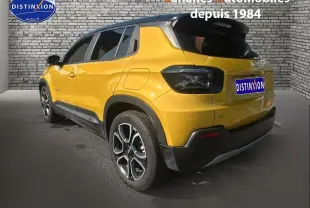 Vue 3/4 arrière droite d'un Jeep Avenger jaune foncé avec toit noir et jantes alliage distinctives.