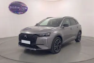 Vue 3/4 avant d'un DS7 2025 gris métallisé avec calandre distinctive et jantes noires dans un studio.