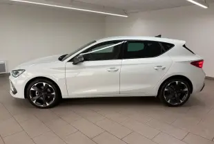 Vue de profil côté gauche d'une CUPRA Leon blanche Nevada 2025 avec jantes noires et vitres teintées.