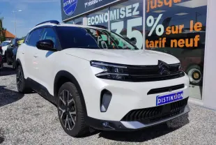 Vue 3/4 avant gauche du Citroën C5 Aircross blanc nacré avec toit noir et jantes alliage bi-ton devant vitrine.