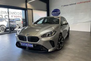 BMW Série 1 120d M Sport gris vue 3/4 avant en intérieur, avec calandre noire et jantes sport noires.