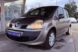 Renault Modus beige vue 3/4 avant droit avec phares allumés et plaque Distinxion visible.