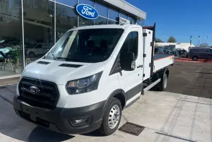 Ford Transit Chassis Cabine blanc en 3/4 avant droit, avec benne et coffre visibles sur parking extérieur.