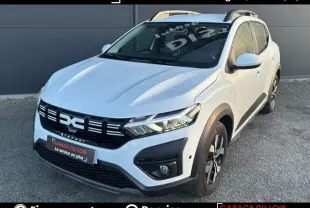 Vue 3/4 avant droite d'une Dacia Sandero Expression TCe 90 blanche de 2025 avec détails noirs et jantes alliage.