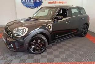 Vue 3/4 avant droite d'un MINI Countryman Cooper SE noir avec jantes noires et détails hybrides visibles sur l'aile.