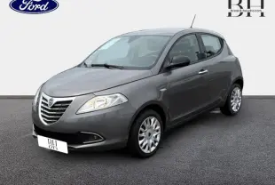 Lancia Ypsilon gris Argento vue 3/4 avant droit, avec calandre chromée et phares halogènes visibles.