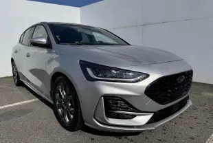 Ford Focus IV ST-Line X gris Moondust métal vue 3/4 avant avec calandre noire et jantes alliage 17 pouces.