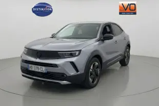 Opel Mokka électrique gris en 3/4 avant droit, avec jantes alliage 17 pouces et vitres surteintées.