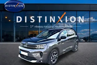 Citroën C5 Aircross gris en 3/4 avant droit, avec jantes alu et toit noir brillant devant showroom Distinxion.