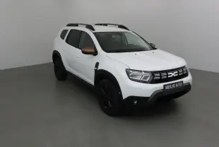 Dacia Duster 4x4 blanc en 3/4 avant droit avec rétroviseurs bronze et jantes noires dans un studio gris.