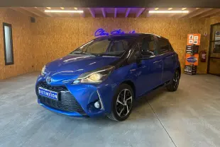 Toyota Yaris hybride bleu en 3/4 avant droit, avec jantes noires et toit noir dans un garage intérieur.