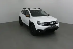 Dacia Duster blanc 4x4 vu en 3/4 avant droit avec rétroviseurs bronze et jantes noires.