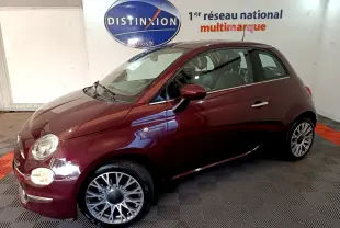 Profil droit d'une FIAT 500 rouge bordeaux 2021 avec jantes alliage et rétroviseurs assortis en intérieur showroom.